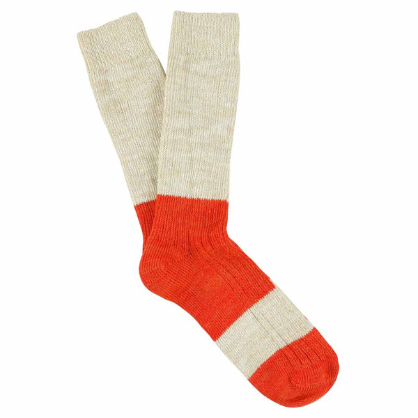 A pair of melange block socks in ecru and orange colors, crafted from cotton blend yarns and made in Portugal