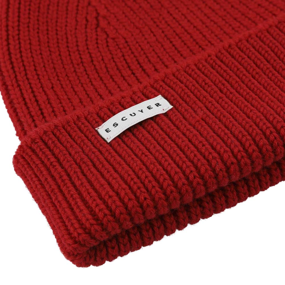 Side view of red ribbed merino wool beanie with folded cuff