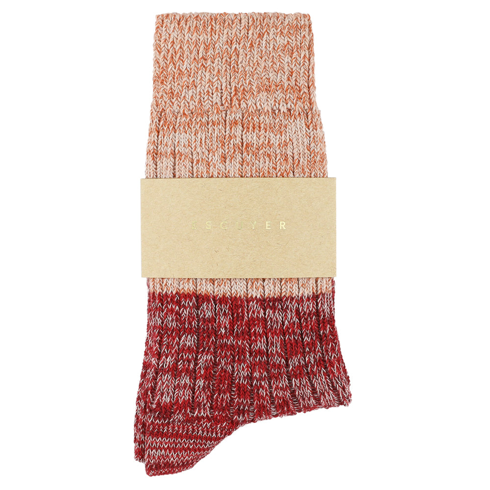 Red and orange patterned sock with a beige band on a white background