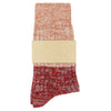 Red and orange patterned sock with a beige band on a white background