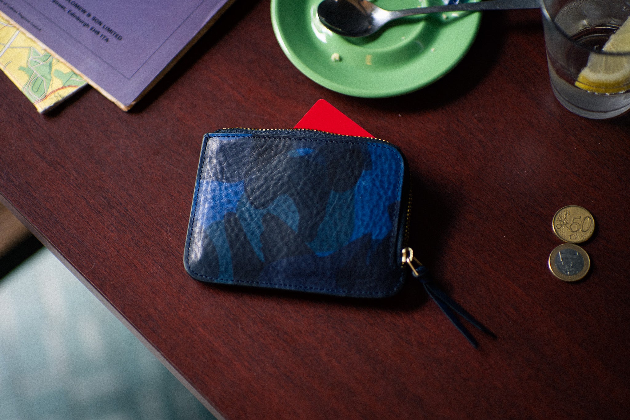 Escuyer blue camouflage zip wallet lifestyle — hand-dyed Italian full-grain veg-tan, made in Portugal