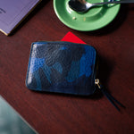 Escuyer blue camouflage zip wallet lifestyle — hand-dyed Italian full-grain veg-tan, made in Portugal