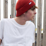 Person wearing an orange ribbed merino wool beanie by Escuyer