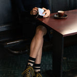 Person wearing black socks with ecru stripes made of wool and cashmere (made in Portugal)